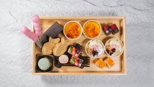 Overhead view of a variety of colorful Japanese desserts elegantly arranged on a wooden tray.